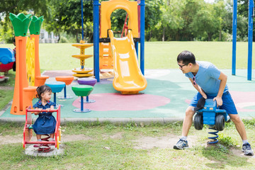 Cute asian little girl playing in the playground with her father, very funny time , concept of love...