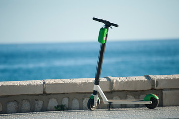 electric scooter parked on the street with sea in the background © Fernando