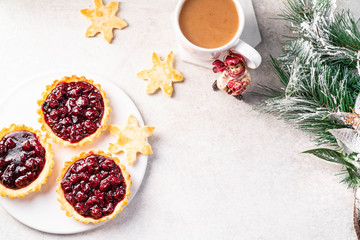 cherry tartlets, and coffee and snowflakes biscuits on a light marble backdrop