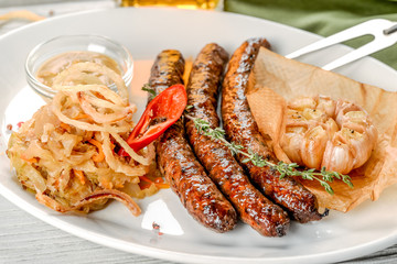Grilled sausages with a side dish in a white plate