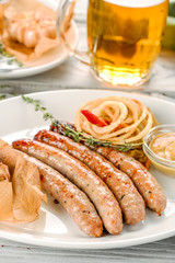 Grilled sausages with a side dish in a white plate