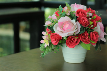 The rose pink red flowers are laid on the table in cafe.