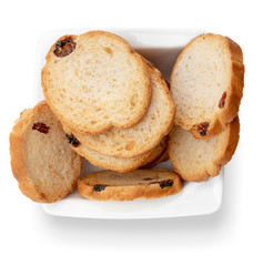 Mini round toasts of bread with raisins in white bowl. Top view. Isolated on white background.