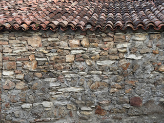 stone wall of the old town with green vines