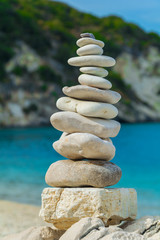A huge tower made of stones on the edge of the beach. Stacked stones, relax on the beach.