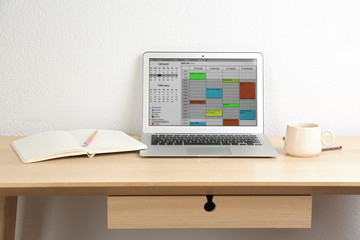 Modern laptop with calendar app in office