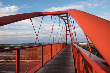 elevated red bridge over the highway without people on cloudy day