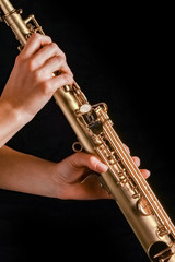 Fototapeta premium soprano saxophone in the hands of a girl on a black background