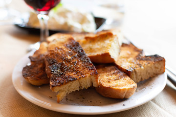 Fototapeta na wymiar Greek food, roasted bread with olive oil and herbs, red wine and tzatziki sauce