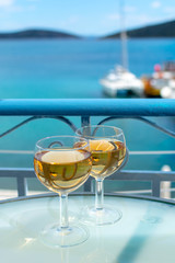 White wine served outside on balcony on glass table with sea view