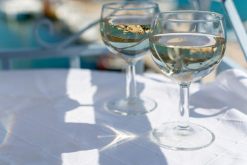 White wine served outside on balcony on glass table with sea view