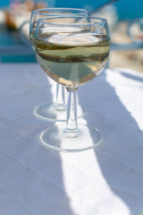 White wine served outside on balcony on glass table with sea view