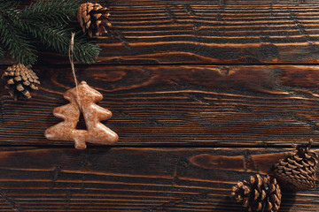 Christmas gingerbread cookies and pine branches and cones on a wooden background, copy space.