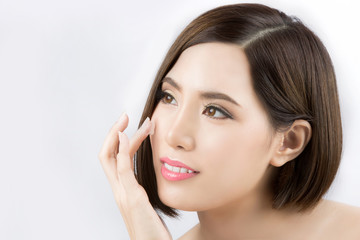 Beautiful Asian woman. She is applying lotion on the face.