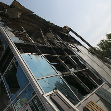 Burned building with broken windows in summer