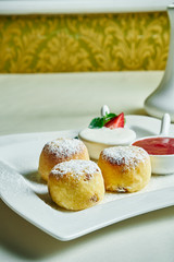 Homemade cheesecakes or Syrniki with jam and sour cream on a white plate. Ukrainian food. Breakfast food