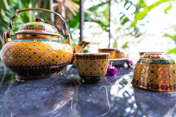 Antique Benjarong porcelain golden tea set on Stone table , ceramics porcelain
