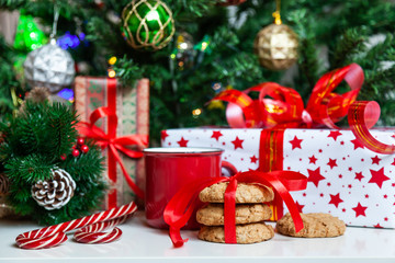 Christmas gift boxes and sweets near decorated Christmas tree