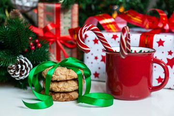 Christmas gift boxes and sweets near decorated Christmas tree
