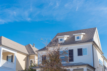 Close-up dormer roof windows on second story of typical houses near Dallas