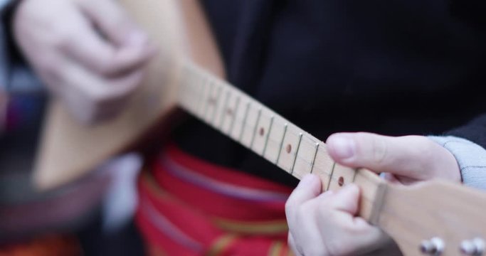 Playing the string balalaika