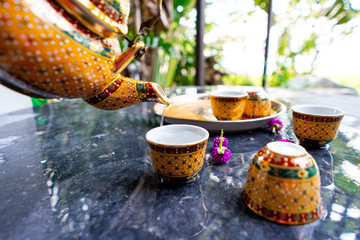 Antique Benjarong porcelain golden tea set on Stone table , ceramics porcelain