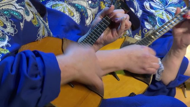Playing the domra. Russian plucked instrument.