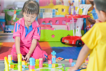 Asian little girl child playing in space toys for children develop in preschool, also known as nursery school