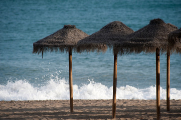 sun umbrellas on the beach waves crash on the sand with white foam
