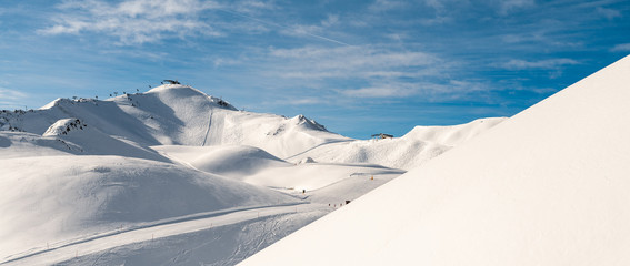 Scenic valley of hilghland alpine mountain winter resort on bright sunny day. Wintersport scene...