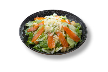 Fresh green salad with salmon fish in beautiful black modern plate