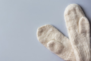 Handmade warm knitted woolen mittens on gray background. Winter eco fashion clothing artisan hand crafted goods knitting hobby concept