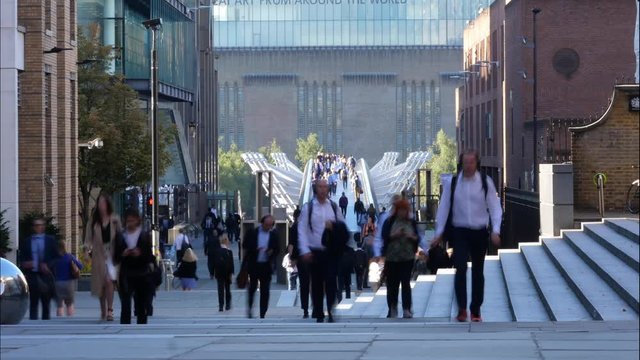 Zoom compressed population busy footbridge Timelaspse of people walking across London Millenium bridge