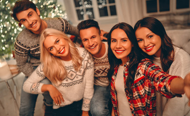 Obraz premium Group of friends celebrating Christmas at home