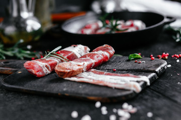 Cooking meat rolls in bacon with spices for grill