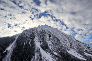 Obraz premium Snowy Mountains peaks in the clouds blue sky Caucasus