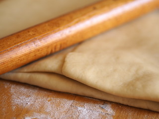 shortcrust pastry with flour and rolling pin on a table