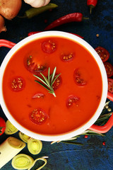 Tomato and fresh rosemary soup with garlic, cracked papper corns, served with cream. Homade tomato soup for dinner