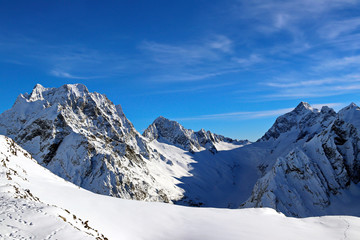 Snowy Mountains peaks in the clouds blue sky Caucasus