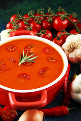 Tomato and fresh rosemary soup with garlic, cracked papper corns, served with cream. Homade tomato soup for dinner