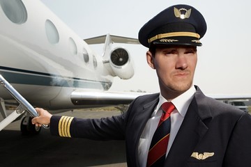 Young business aviation pilot near the plane