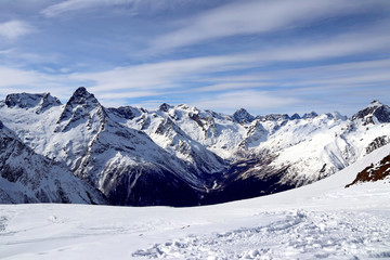 Fototapeta na wymiar Snowy Mountains peaks in the clouds blue sky Caucasus