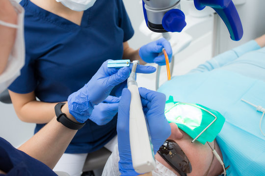 Close-up picture of dental instruments: drill and needle for root canal treatment and pulpitis in hand at the dentist in a blue glove