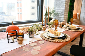 The concept of designing a room in a natural style. Photo of a beautifully furnished interior with decorative elements on the table in a rustic image of a cozy house.
