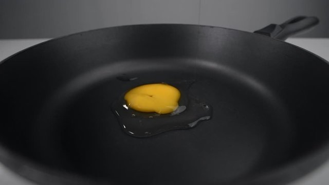 Raw egg falls to the pan and smashes in slow motion, falling egg in 240 fps, cooking at the kitchen, Full HD 240p Prores 422 HQ