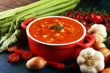 Minestrone soup in a bowl on a light table, top view. Italian soup with pasta and seasonal...