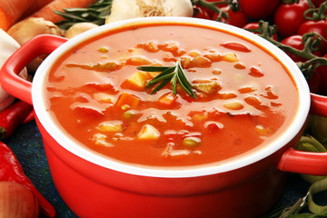 Minestrone soup in a bowl on a light table, top view. Italian soup with pasta and seasonal vegetables. Delicious vegetarian food concept.