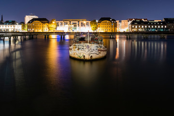 An old boat has run aground on a river, colorful night shot with a boat running aground, Berlin City, Spree,Treptower Park