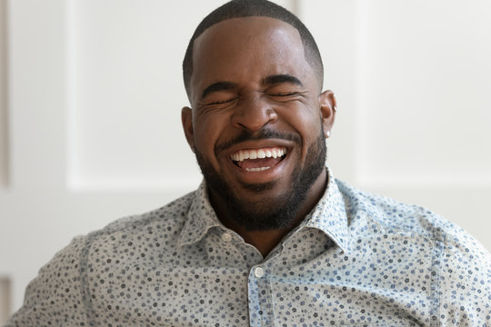 Portrait of excited afrcian American man laughing showing teeth