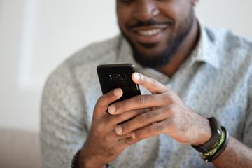 Close up of smiling biracial man using modern smartphone gadget